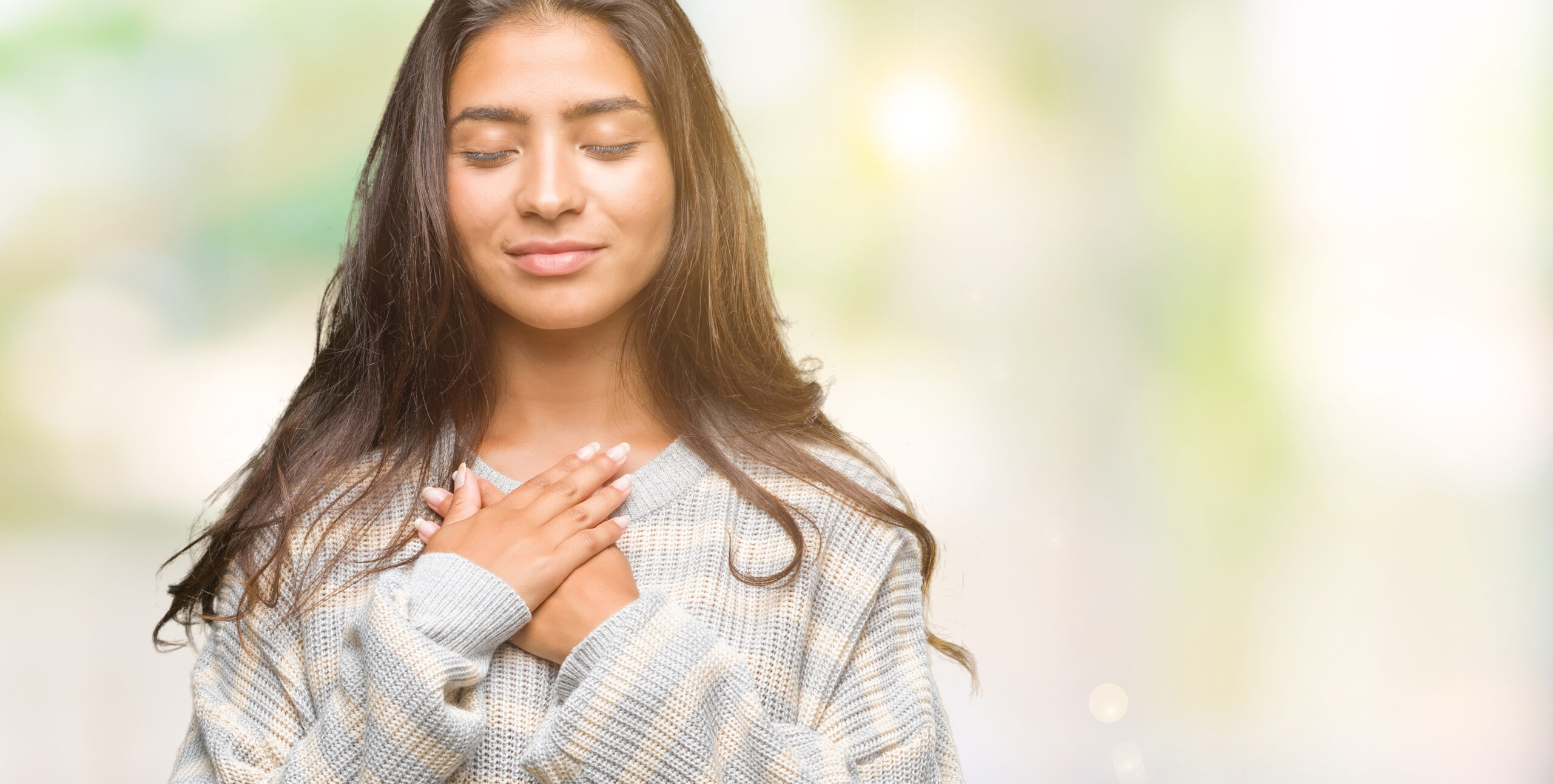 Smiling woman with eyes closed and both hands resting over her heart, illustrating how to guard your heart from offense with scripture, inspired by The Unoffendable Heart by Mike Signorelli.